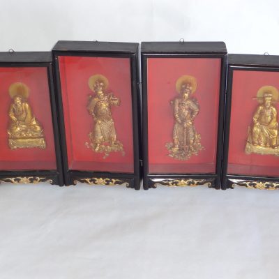 Four antique hand-carved wood and gold lacquer Chinese warrior and Buddha figures in ornate shadow box frames.
