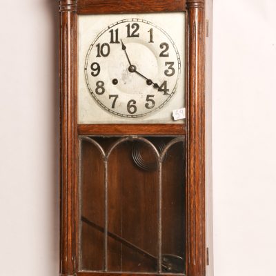 59   8 Day wall clock.  Oak cased      with leaded glass front and  Arabic numeral face.  New  Haven Company.  Early 20th  century.