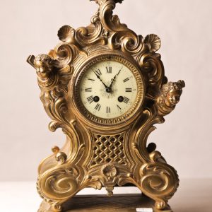 9.  French mantle clock. Roman numeral face and brass case with cherub motif. Late 19th century.  