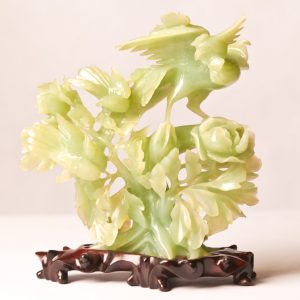 8.  Chinese serpentine jade carving. Near Celadon colouring, depicting birds on a bush. 7"H. Mid 20th century. On wooden base.  