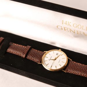 5.  Men's 14kt yellow gold wristwatch. Leather strap. With original $1495.00 price tag still attached. Late 20th century.  