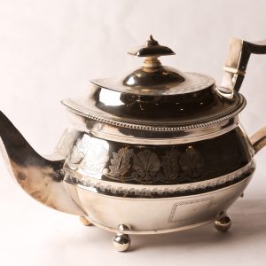 13. Sterling silver teapot. Hand chased foliage design, with ivory stoppers, hinged lid and bun feet. Not monogrammed. Robert and Samuel Hennell, London, 1812.  