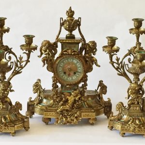 35a. Garniture set.  Ornate brass construction with clock and candleabras in cherub and foliate motif.  Mid 20th century.