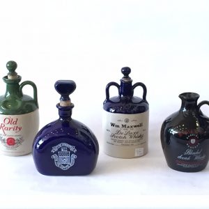 98. Whiskey jug collection. McGibbon's; Bulloch Lade; Wm. Maxwell; and City of Winnipeg collector’s bottle.  All with original cork stoppers. Mid 20th century.